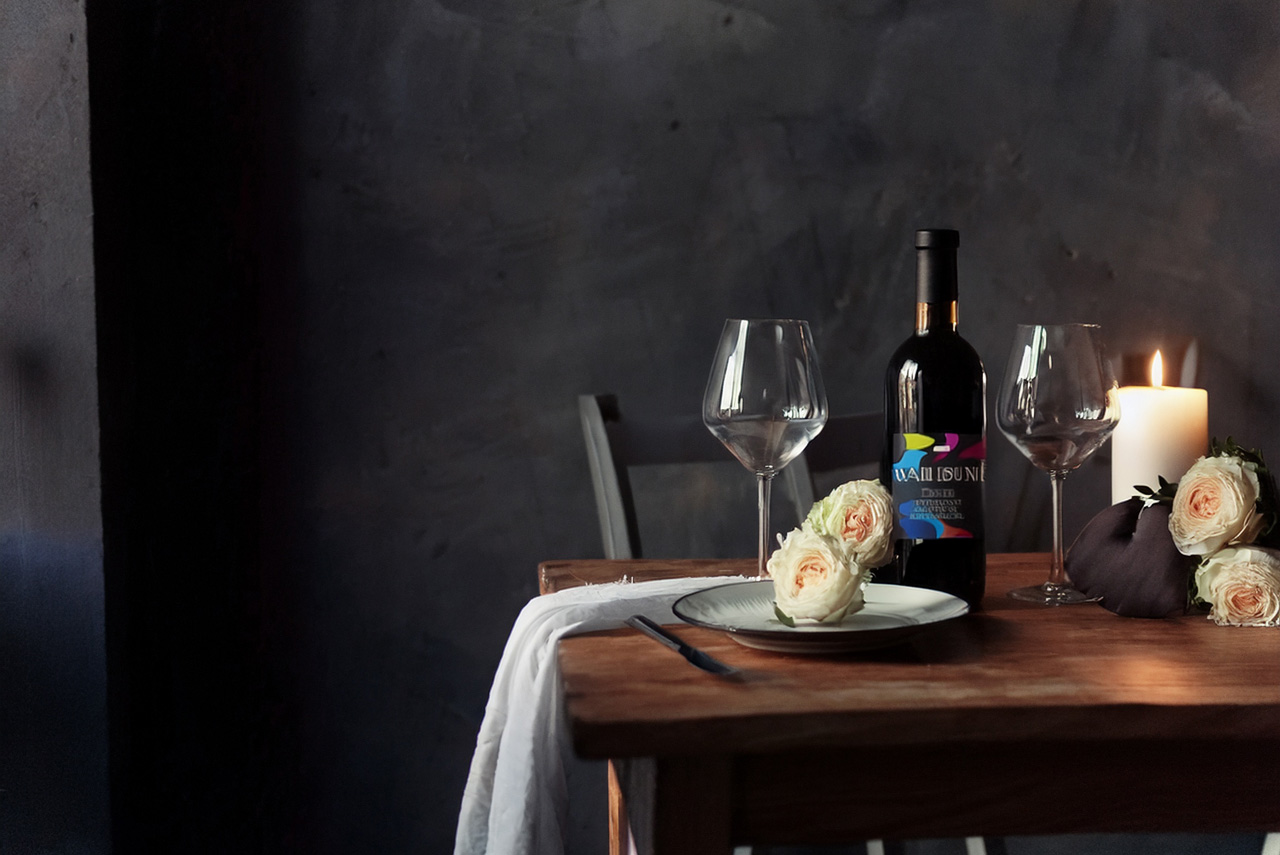 Wine Subscription Gift for Anniversaries: Make It Memorable 2 A table set for a romantic anniversary dinner with candles, roses, and wine bottles from The Grape Reserve.