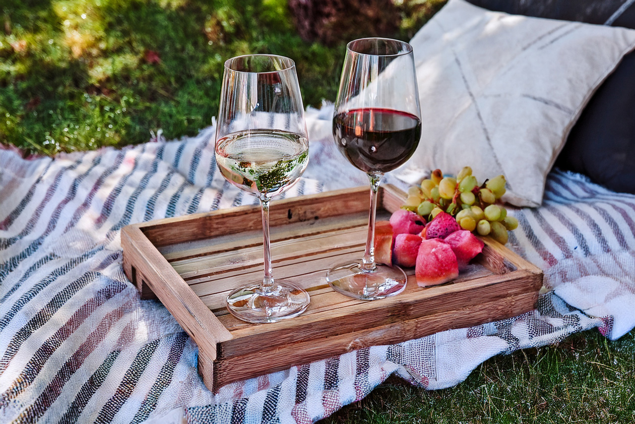 Outdoor summer table with wine glasses and gift box from The Grape Reserve.